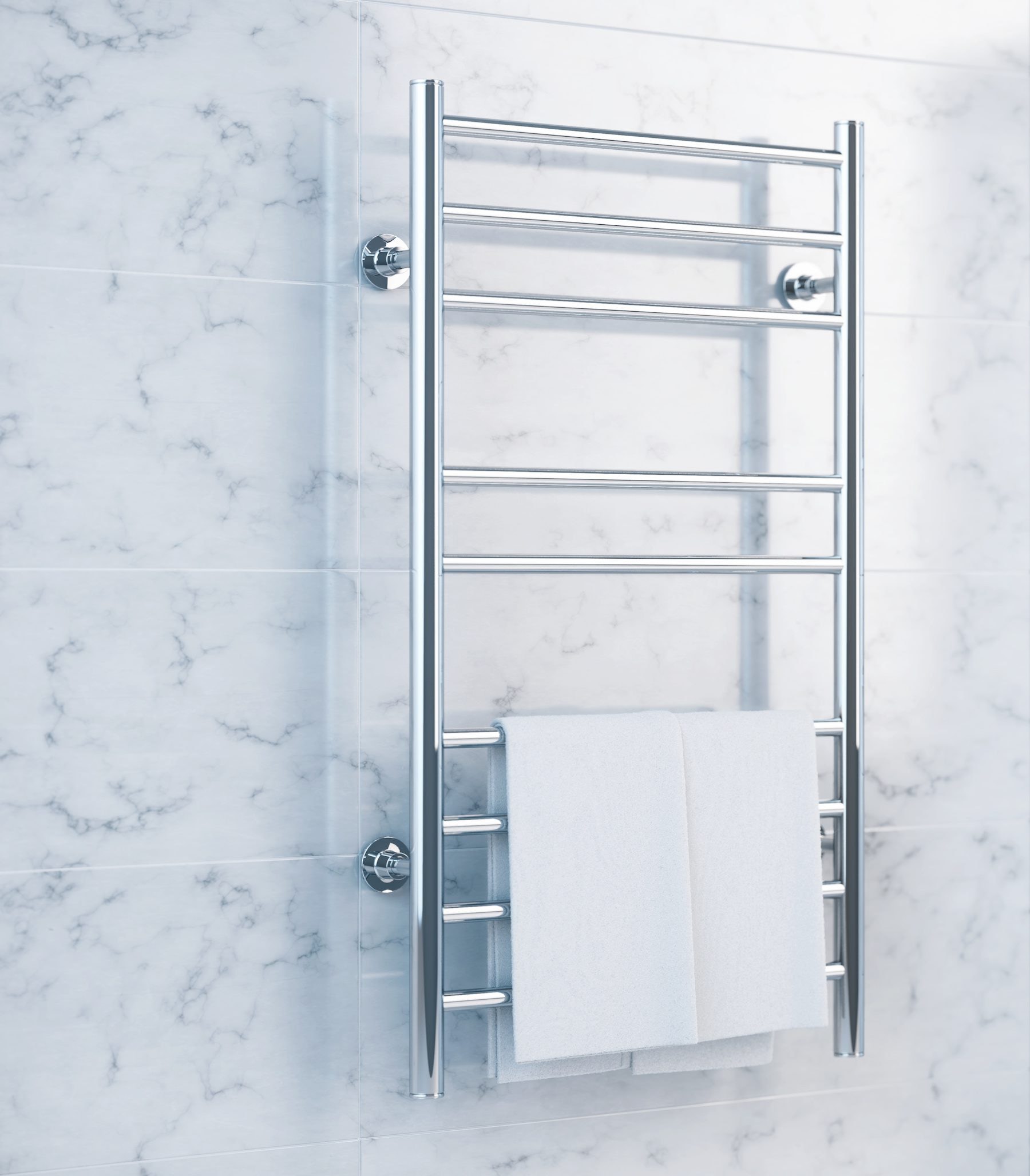 A chrome heated towel rail with a white towel against a marble-effect wall.