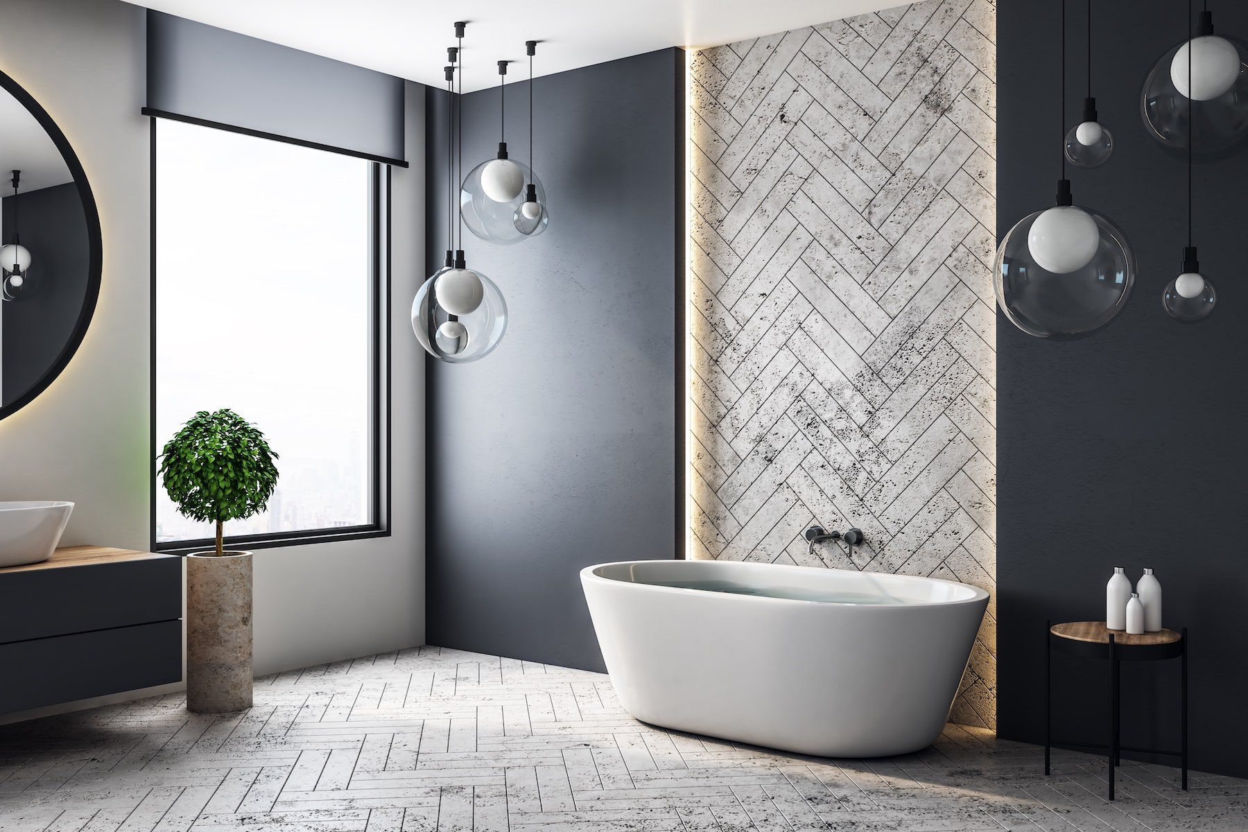 A freestanding bath beneath a tall window, with dark walls, a herringbone-tiled feature wall and glass globe pendants.